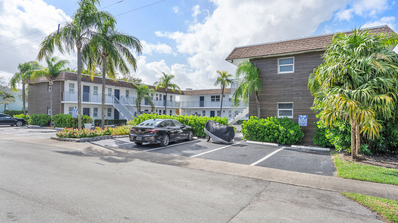 Apartment complex with parking lot and palm trees in Fort Lauderdale managed by Threshold Management