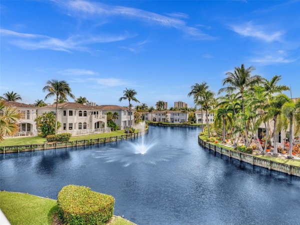 Waterfront view of Aventura condos with palm trees and fountain