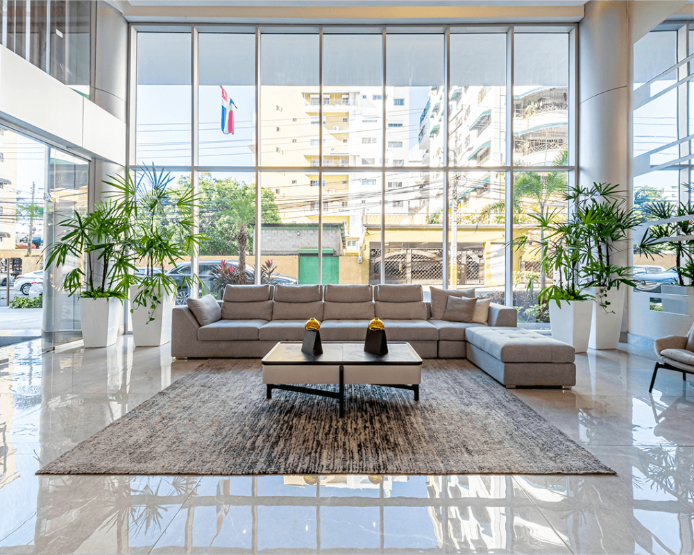 Modern apartment lobby interior with large windows, neutral sofas, and indoor plants – Threshold Property Management Brickell