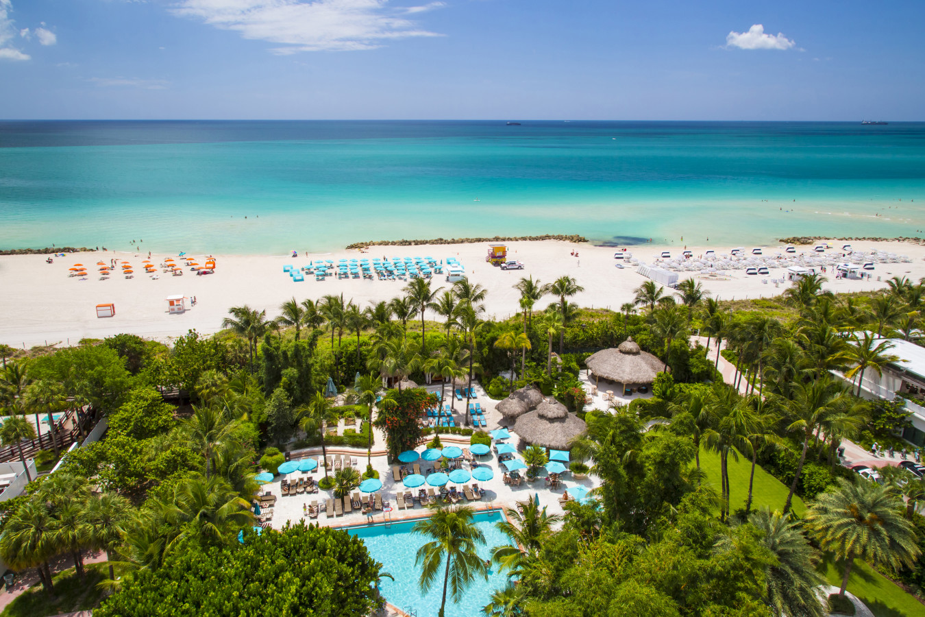 Aerial view of the beach and turquoise ocean in Fontainebleau with palm trees and pool area managed by Threshold Management