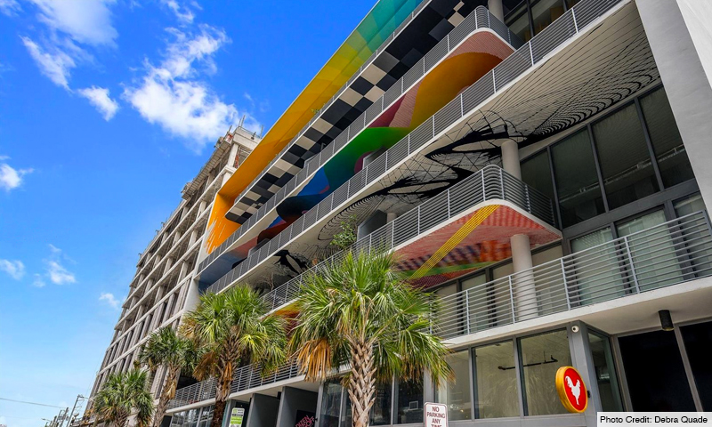 250 Wynwood Building with colorful balcony designs and palm-lined sidewalk