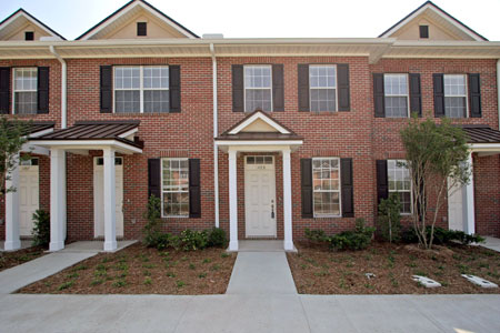 Front exterior view of Kendall Pointe townhomes with brick façade and white trim
